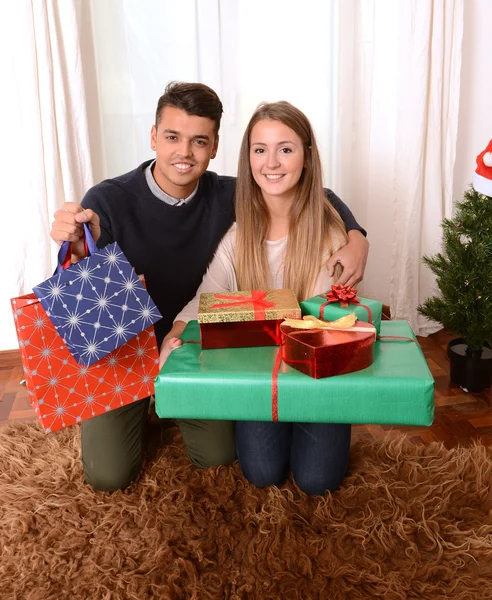 Jovem casal feliz segurando presentes de Natal — Fotografia de Stock