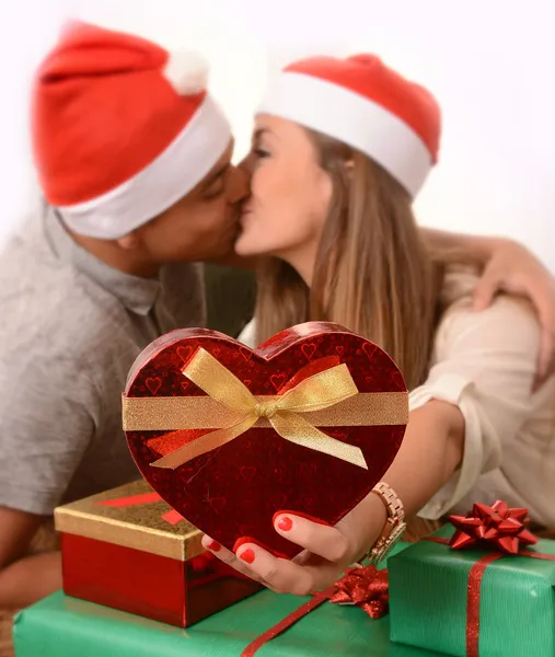 Молодая счастливая пара целуется на ковре на Рождество — стоковое фото