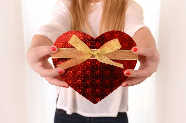 Mujer sosteniendo corazón en forma de caja presente —  Fotos de Stock