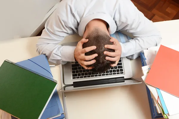 Gestresster Student oder Geschäftsmann auf der Tastatur — Stockfoto