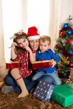 genç anne oğlu ve kızı ile Noel Baba şapkalı