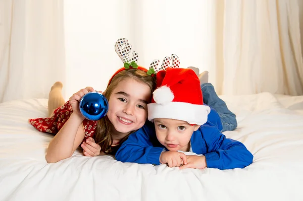 Glückliches süßes kleines Kind und seine Schwester zu Weihnachten — Stockfoto