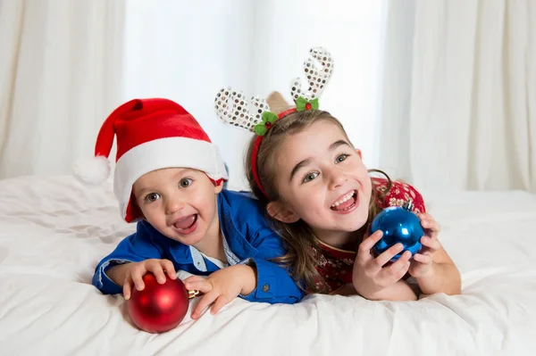 Glad söt liten unge och hans syster vid jul — Stockfoto