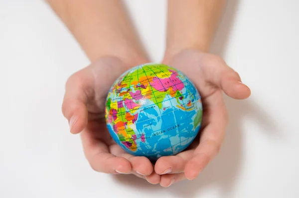 Niña sosteniendo el pequeño globo mundial en sus manos —  Fotos de Stock