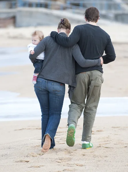 Jong koppel lopen op zand strand met baby — Stockfoto