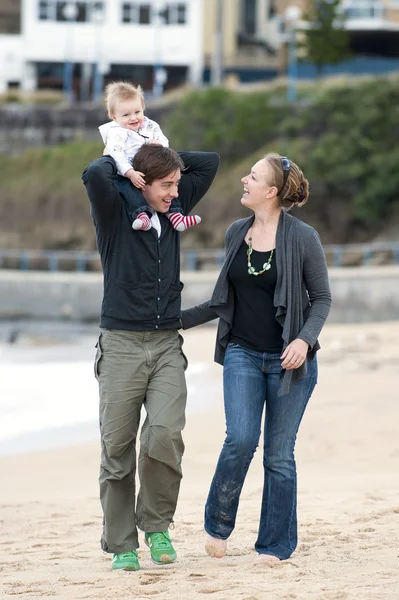 Ungt par promenader på stranden sand med baby — Stockfoto