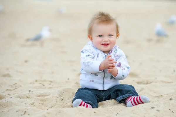 Liten unge på sandstranden och måsar — Stockfoto