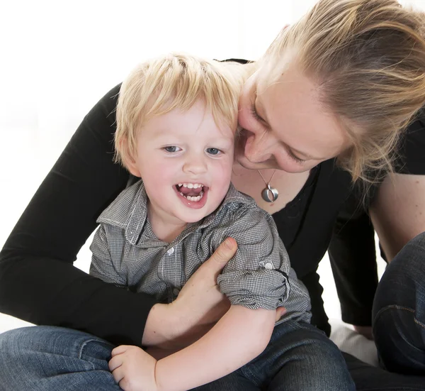 Giovane madre che abbraccia il suo piccolo bambino biondo carino — Foto Stock