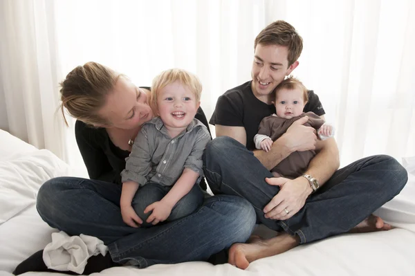 Pareja joven jugando con la niña y el niño pequeño — Foto de Stock