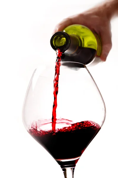 Homem mão segurando garrafa de enchimento de vidro com vinho tinto — Fotografia de Stock