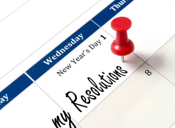 Pin on calendar pointing new year resolutions — Stock Photo, Image