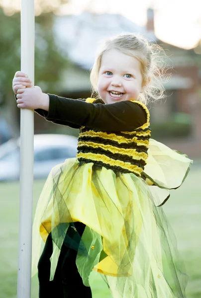 Little blond girl in bee costume playing outdoors — Stock Photo, Image