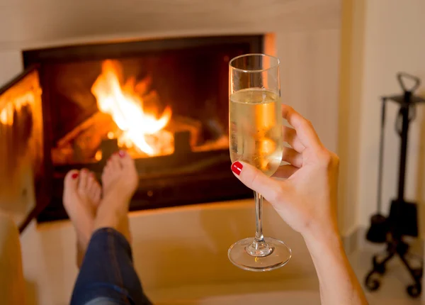 Woman drinking Champange in front of a fire — Stock Photo, Image