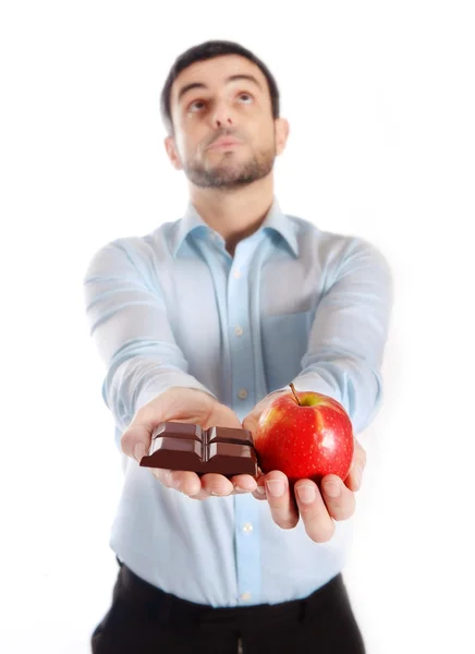 Homem atraente segurando Chocolate e Apple — Fotografia de Stock