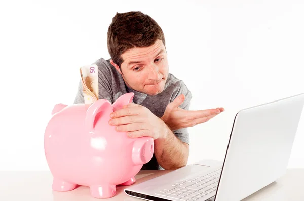 Man met piggy bank en laptop denken over online opslaan — Stockfoto