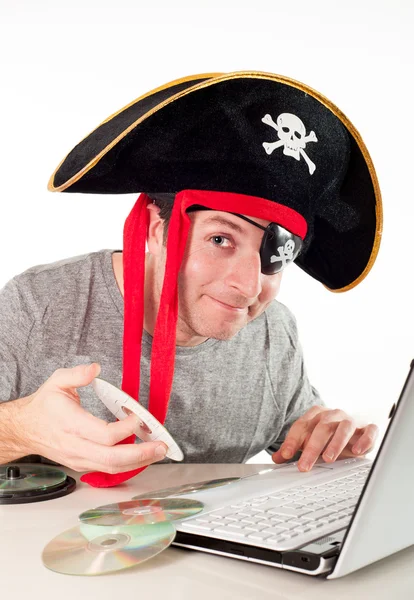 在下载音乐在笔记本电脑上的海盗帽子的男人 — 图库照片
