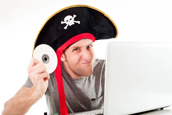 Man in pirate hat downloading music on a laptop — Stock Photo, Image