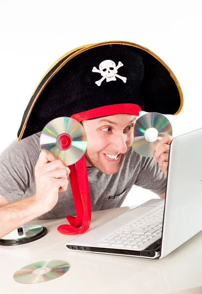 Hombre en sombrero pirata descargar música en un ordenador portátil —  Fotos de Stock