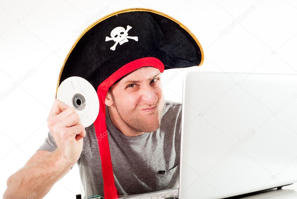 man in pirate hat downloading music on a laptop