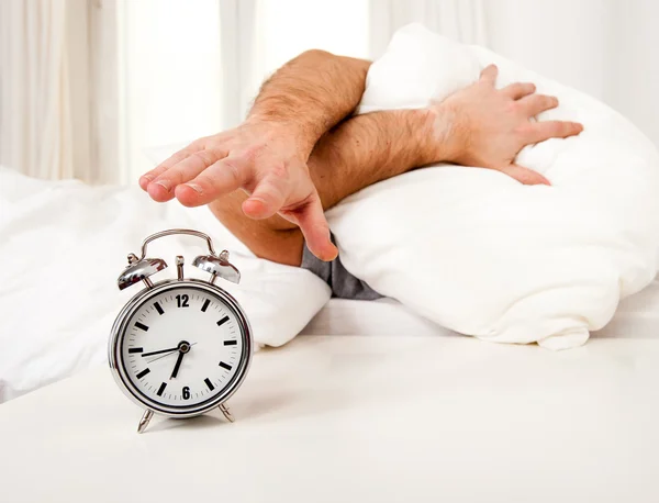 Sleeping man disturbed by alarm clock early morning — Stock Photo, Image
