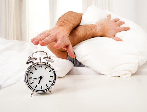 sleeping man disturbed by alarm clock early morning