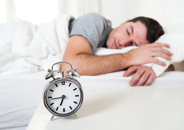 Junger attraktiver Mann schläft auf Bett Stockfoto