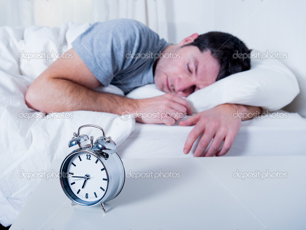 Young attractive man sleeping on bed