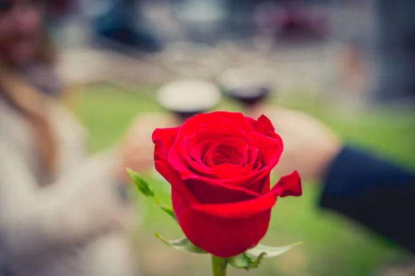 Close up a single rose with a coule drinking wine — Stock Photo, Image
