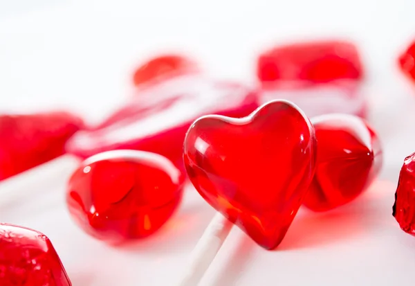 Macro corazón rojo con chocolates y piruletas sobre fondo blanco — Foto de Stock