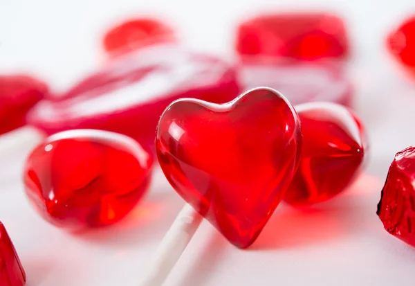 Macro corazón rojo con chocolates y piruletas sobre fondo blanco — Foto de Stock