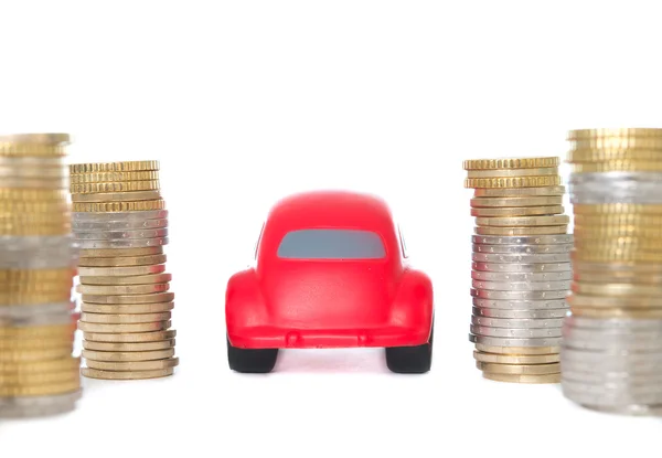 Macro of a red toy car driving through coins — Stock Photo, Image