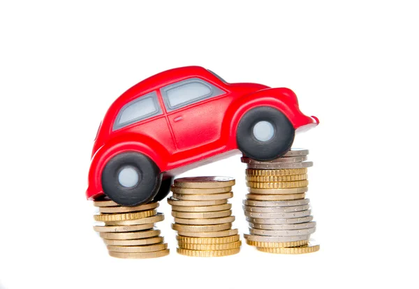 Macro de um carro de brinquedo vermelho em uma pilha de moedas de euro — Fotografia de Stock