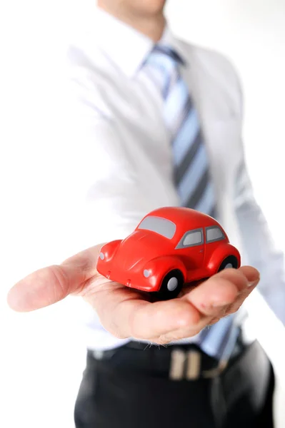 Macro rojo juguete coche en hombre de negocios mano — Foto de Stock