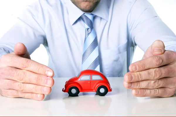 Макро красный автомобиль игрушки и руки бизнесмена — стоковое фото