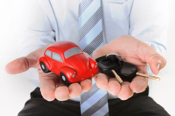 Carro de brinquedo vermelho macro com chaves de carro na mão mans — Fotografia de Stock