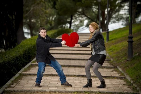 Casal atraente lutando por um travesseiro coração amor — Fotografia de Stock
