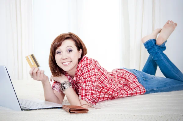 Mujer atractiva feliz con pelo rojo compras en línea —  Fotos de Stock