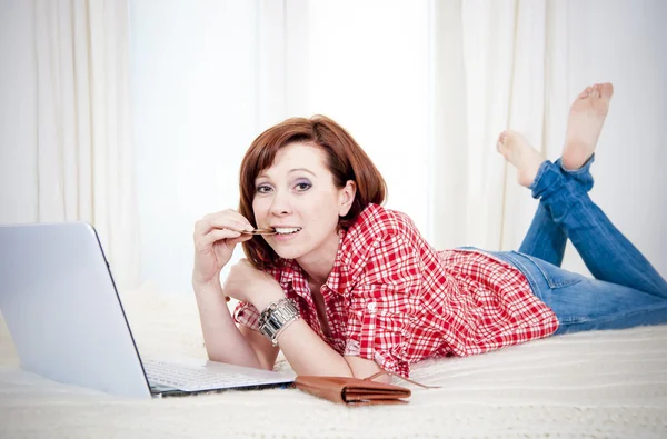 Worreid red haired woman online shopping on white background — Stock Photo, Image