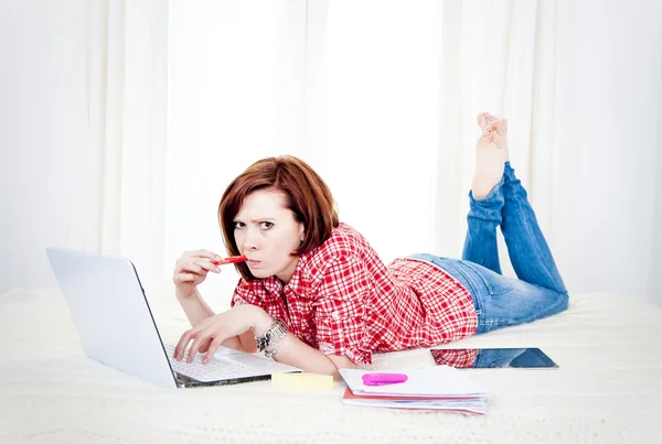 Czerwone włosy studenta, biznes kobieta leżąc działa na laptopie — Zdjęcie stockowe