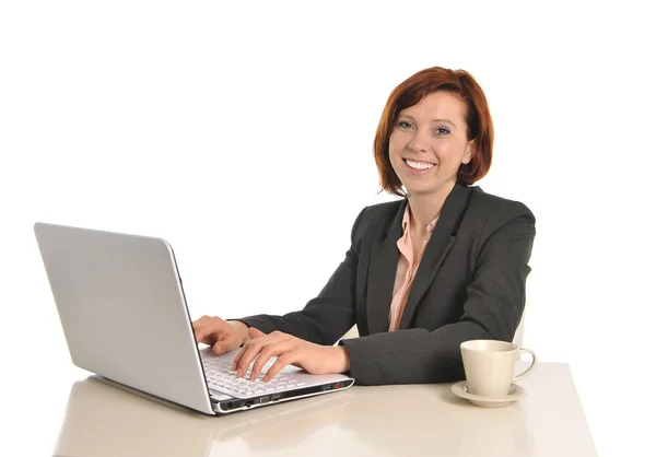 Счастливая деловая женщина с рыжими волосами пьет кофе и улыбается — стоковое фото