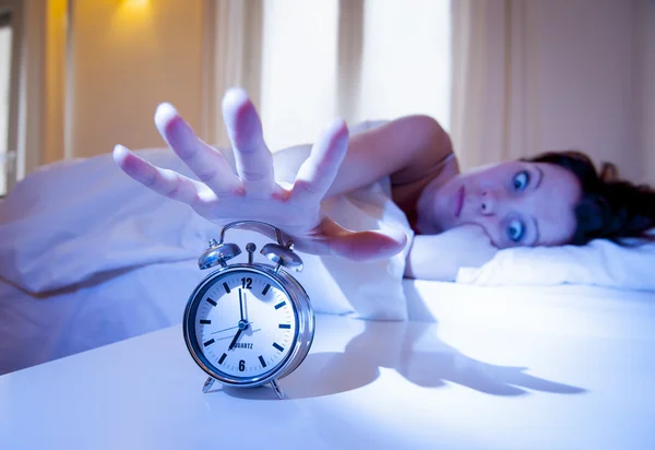Close up alarm clock with red haired woman turning it off — Stock Photo, Image