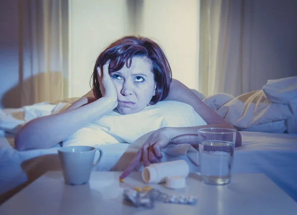 Рыжая женщина, больная в постели лекарством — стоковое фото