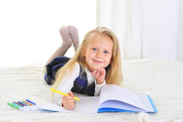 Adorable niña rubia en la cama dibujo con marcadores —  Fotos de Stock