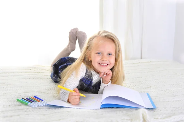 Urocza blondynka dziewczynka na łóżku rysunek ze znacznikami — Zdjęcie stockowe