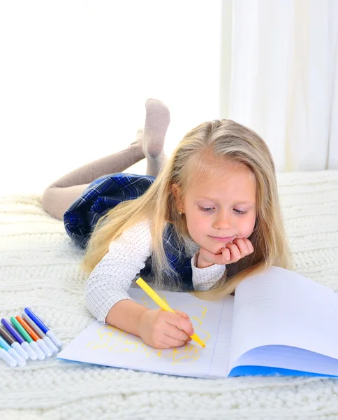 Adorable blonde little girl on bed drawing with markers — Stock Photo, Image