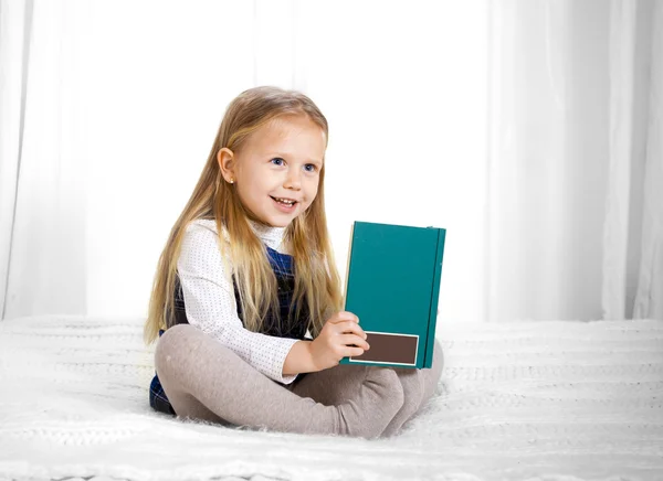 Boldog aranyos szőke hajat iskola lány egy könyvet olvas — Stock Fotó