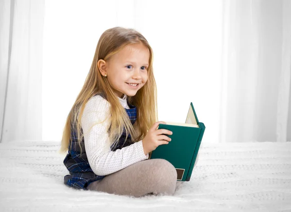 Feliz bonito loira cabelo escola menina lendo um livro — Fotografia de Stock