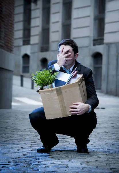Frustrated business man on street fired carrying cardboard box — Stock Photo, Image