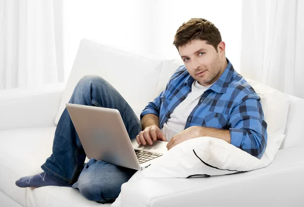 Attraktiver Mann mit Computer auf Couch — Stockfoto