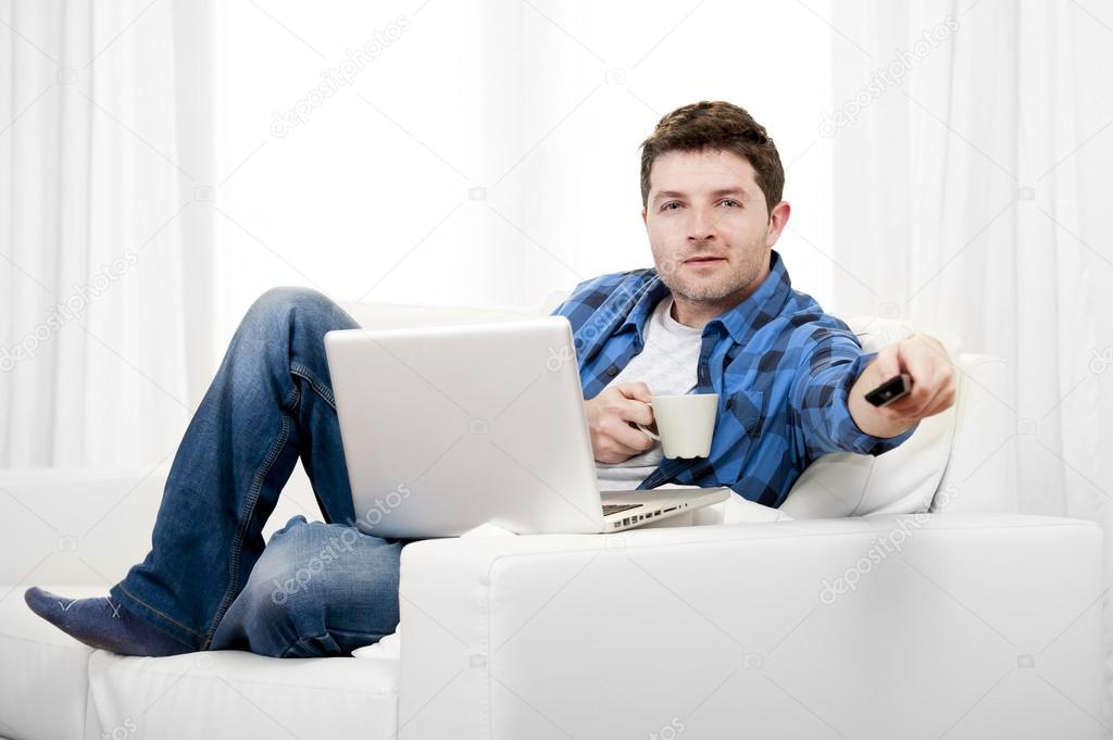 Relaxed man using Computer at home switching tv on